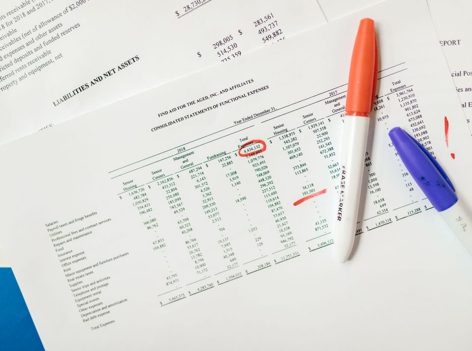Close-up of financial documents with highlighted figures and marker pens