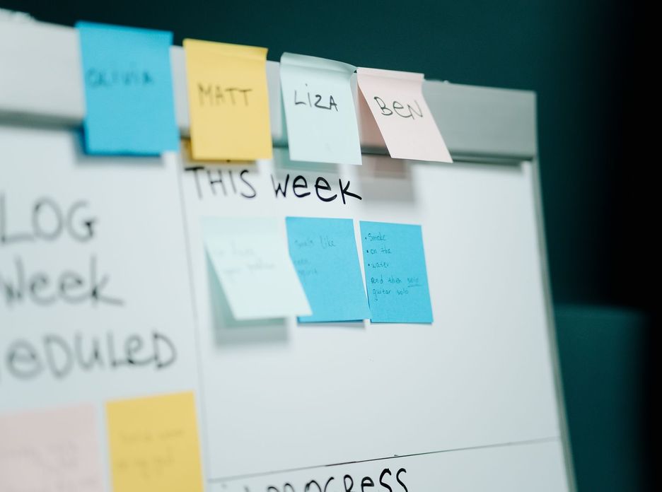 Close-up of a whiteboard with colorful sticky notes for task organization and planning