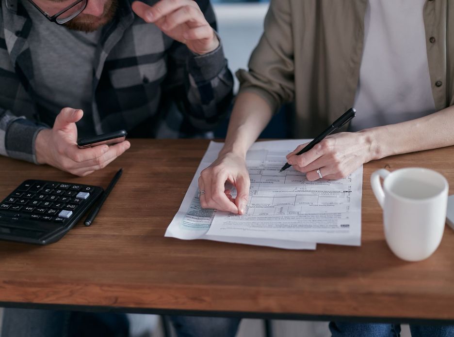 A couple collaboratively managing finances with papers and calculator in hand