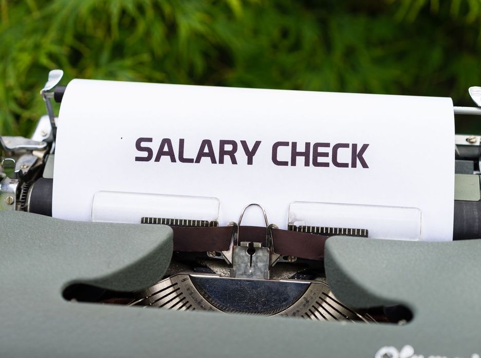 Close-up of a vintage typewriter typing 'Salary Check' on paper