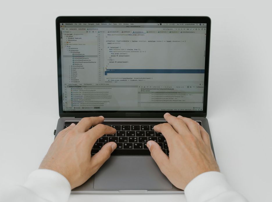 Close-up of hands coding on a laptop