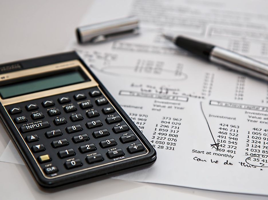 Close-up of financial documents with calculator and pen
