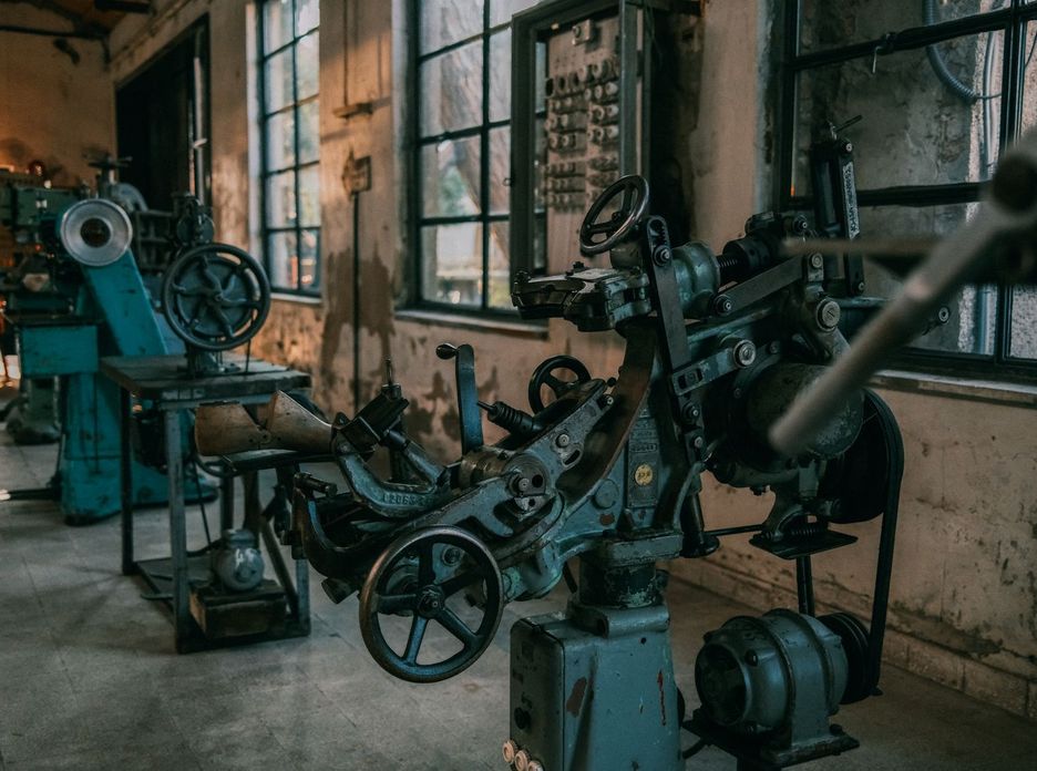 Old industrial machines in an abandoned workshop with vintage tools and equipment