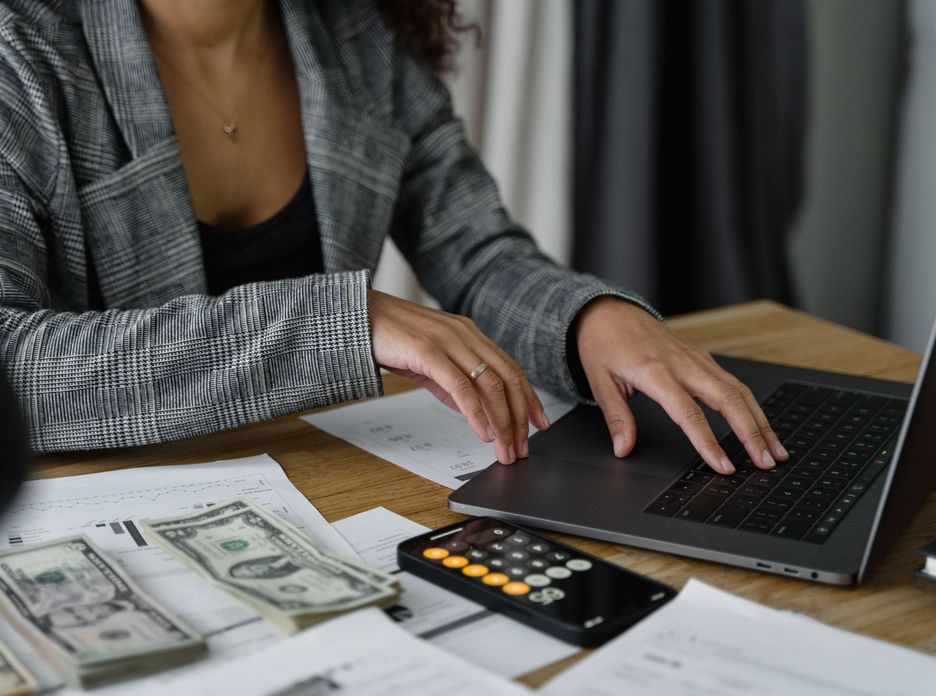 A businesswoman working on finance management with cash and calculator on desk