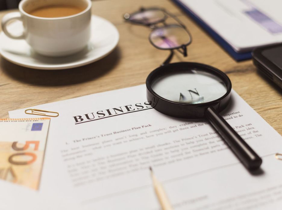 A business workspace setup featuring documents, coffee, and financial elements