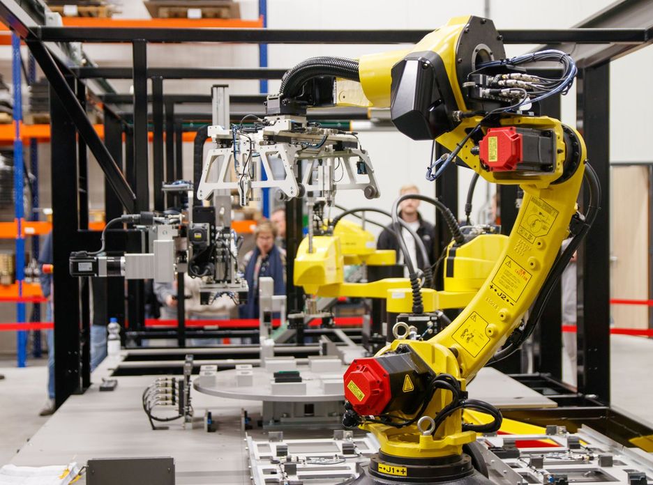 Close-up of a yellow industrial robotic arm in action at a modern manufacturing facility